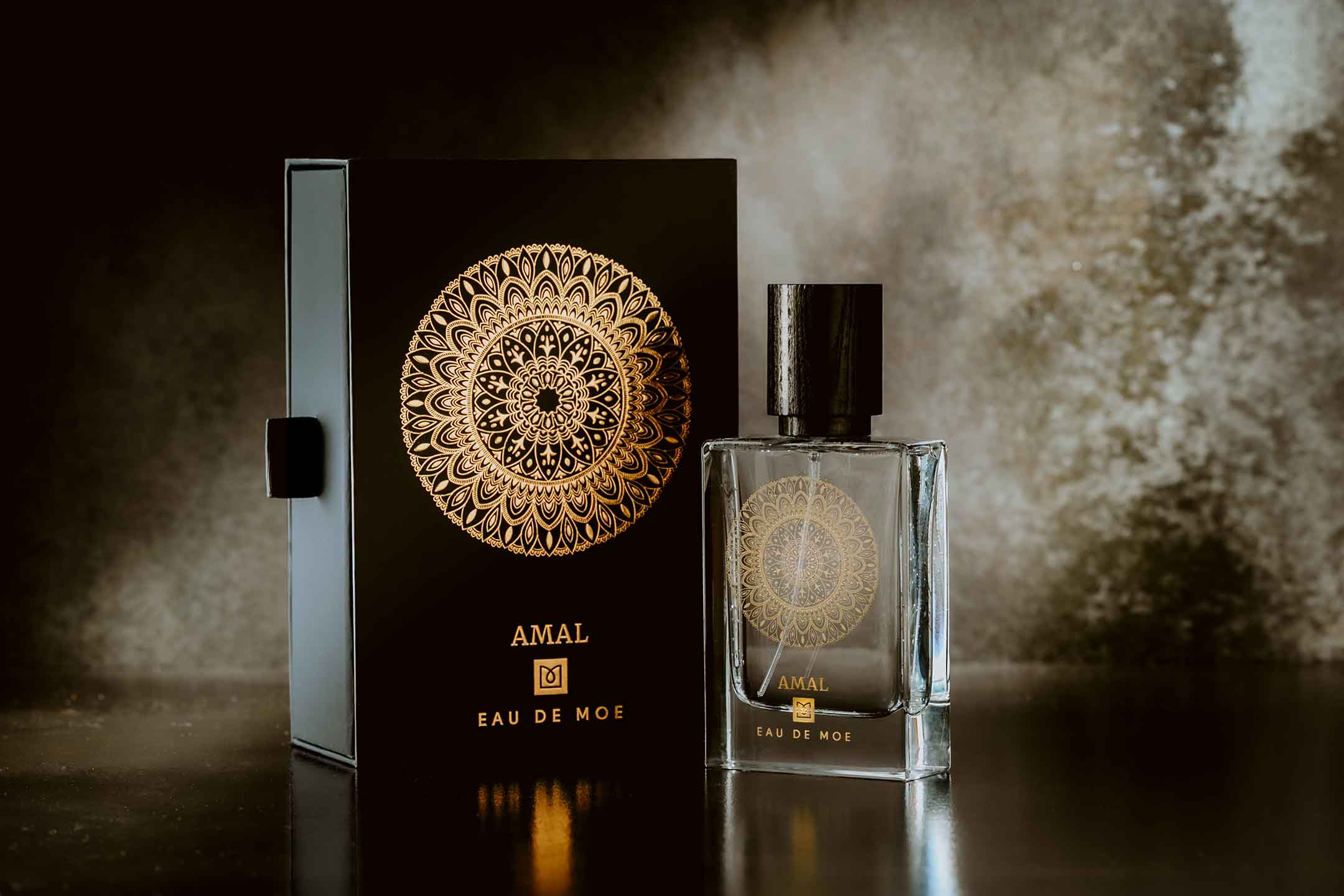 Image of bottle and box of AMAL EDP on a dark background with highlights