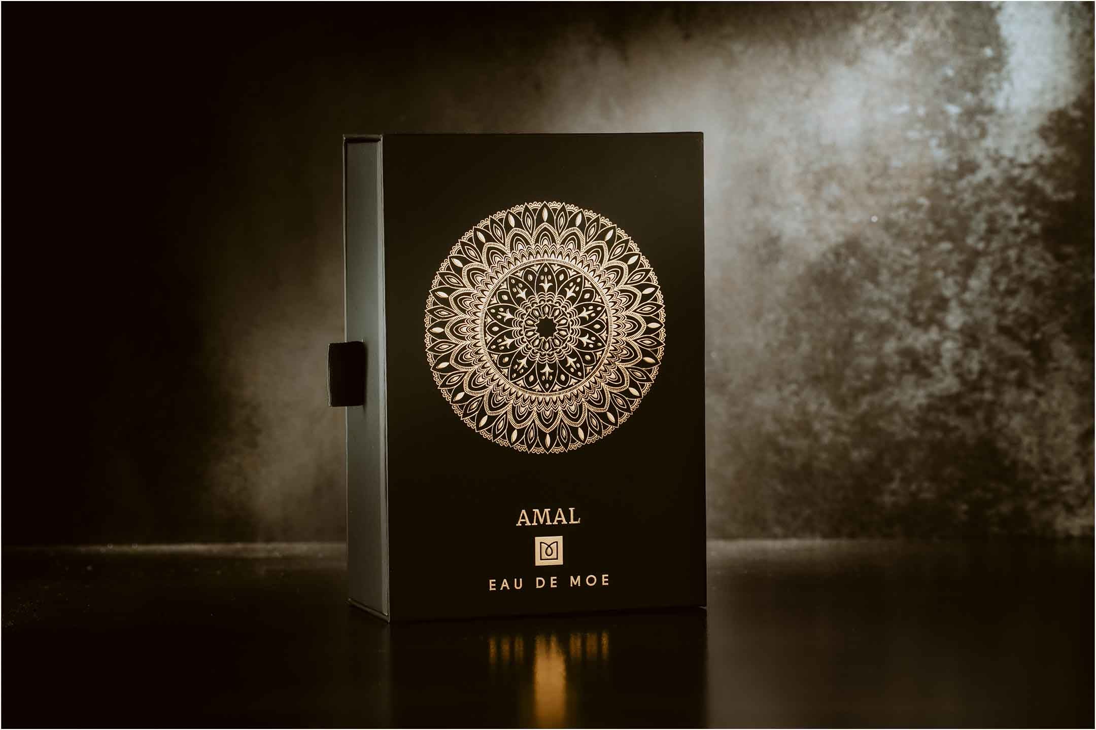 AMAL EDP perfume box with a gold mandala on a dark base and dark background
